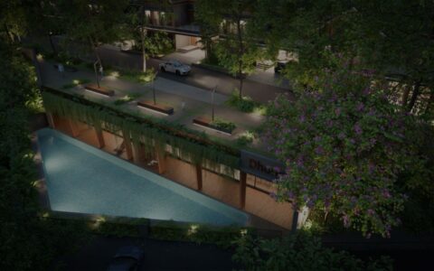 Luxury gated villas in Malappuram with a landscaped swimming pool, greenery, and modern community amenities at night.