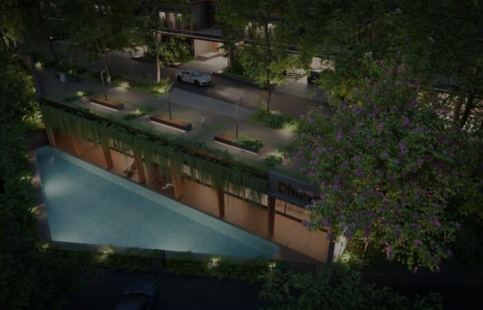 Luxury gated villas in Malappuram with a landscaped swimming pool, greenery, and modern community amenities at night.
